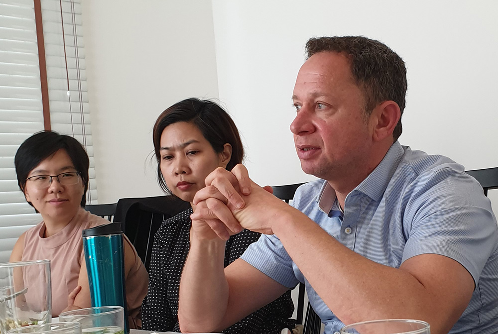 Alexander Bukh chatting at a table with fellow delegates