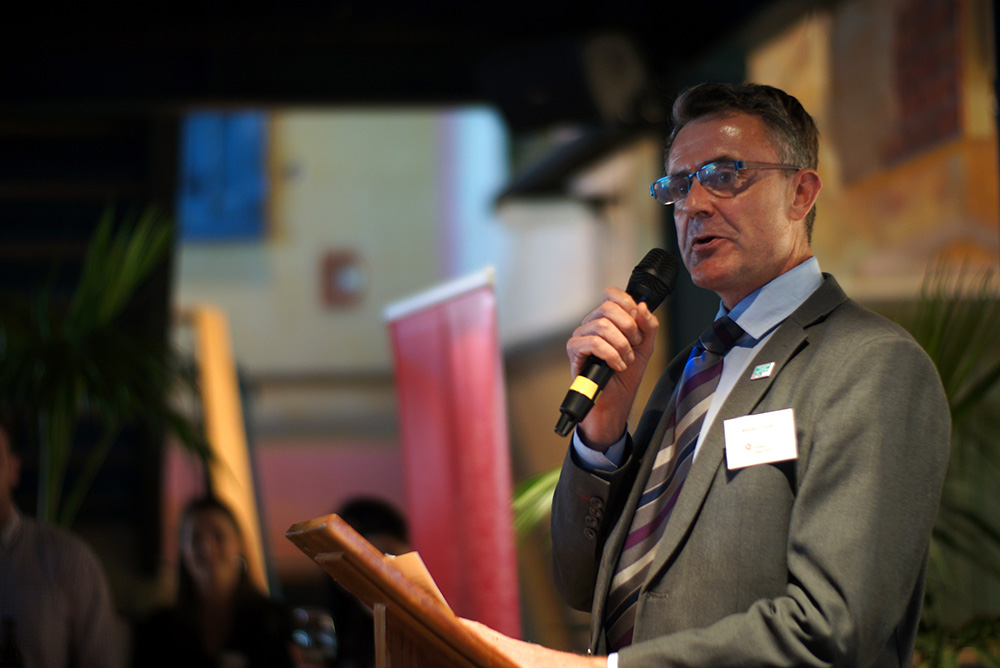 Alistair speaking from a podium