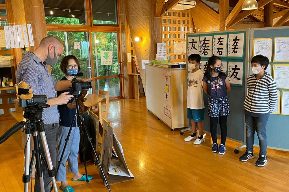Two members of NZ Embassy staff in Tokyo filming three children for a language video