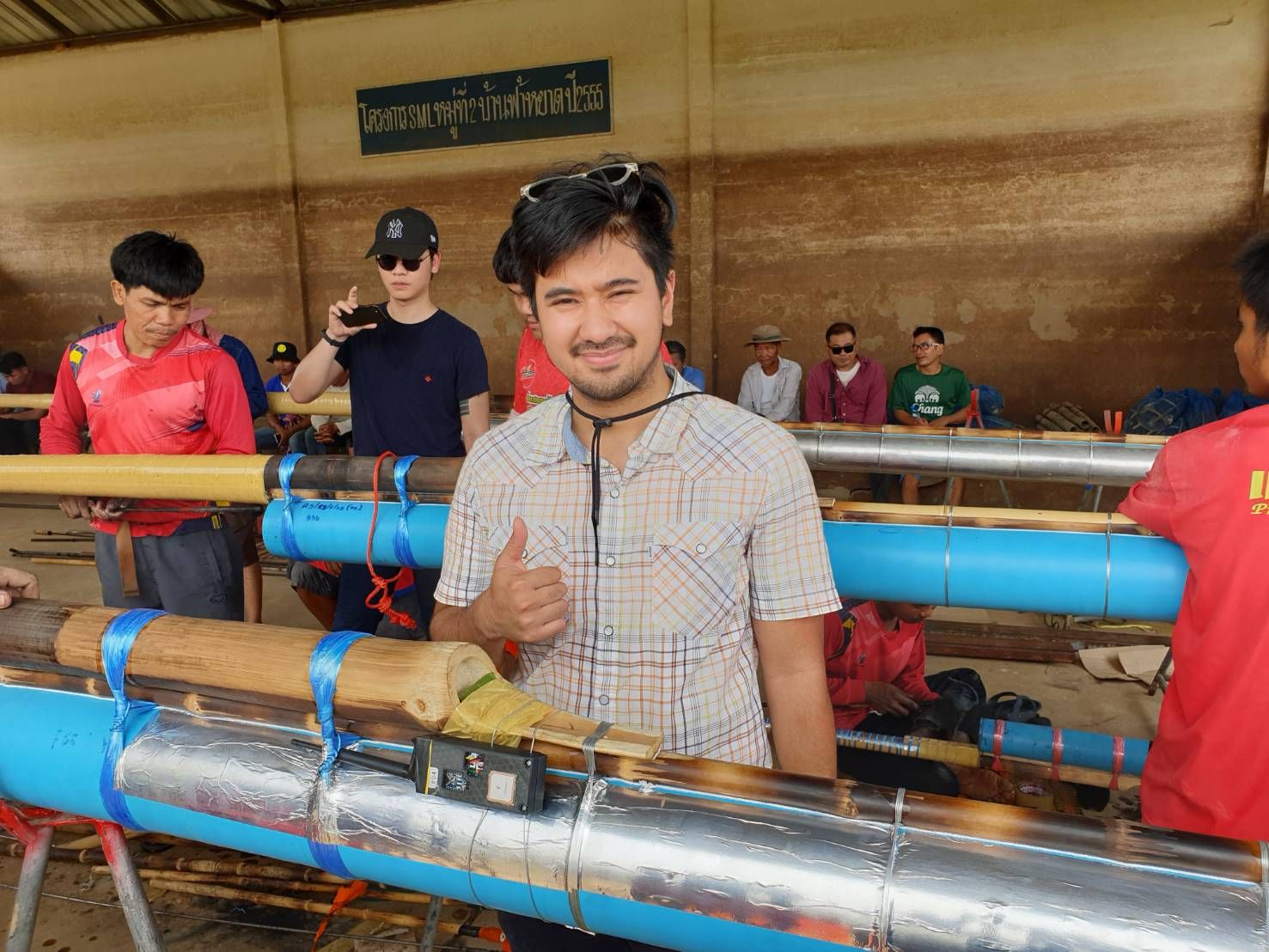 Mikhael giving a thumbs up beside a homemade rocket