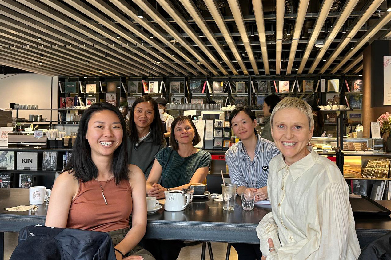 Five curators sitting at a bar in a cafe