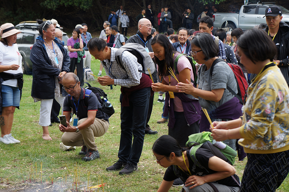 People paying their respects by burning incense