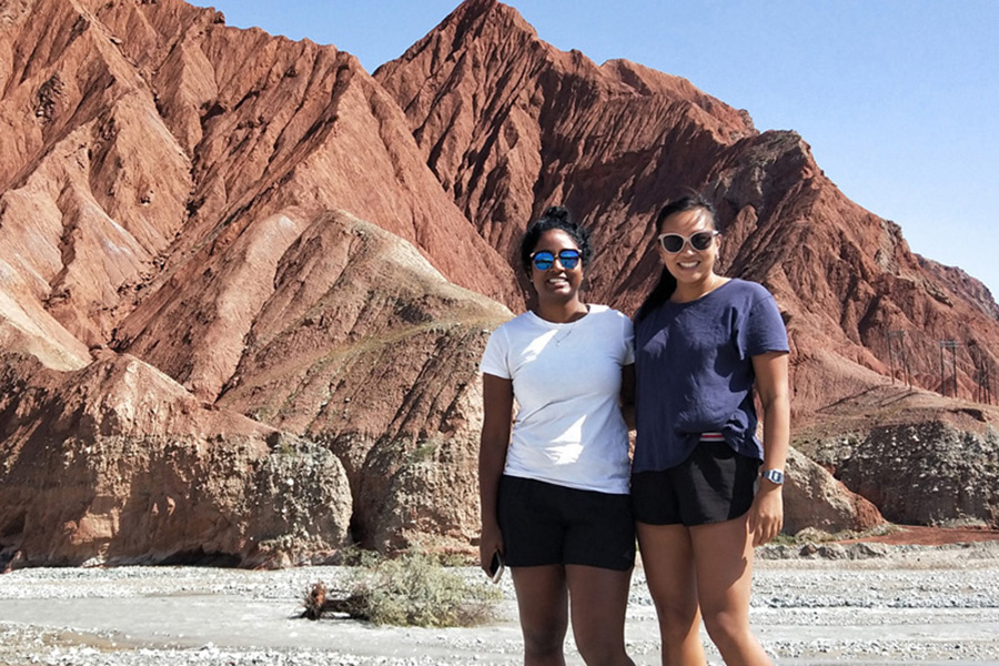 Wei Wei (standing in front of a red-clay hill with fellow Leadership Network member Dhaxna Sothieson
