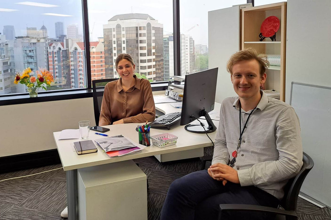 Grace and fellow intern Stephen Jannink sitting on either side of a desk in an office