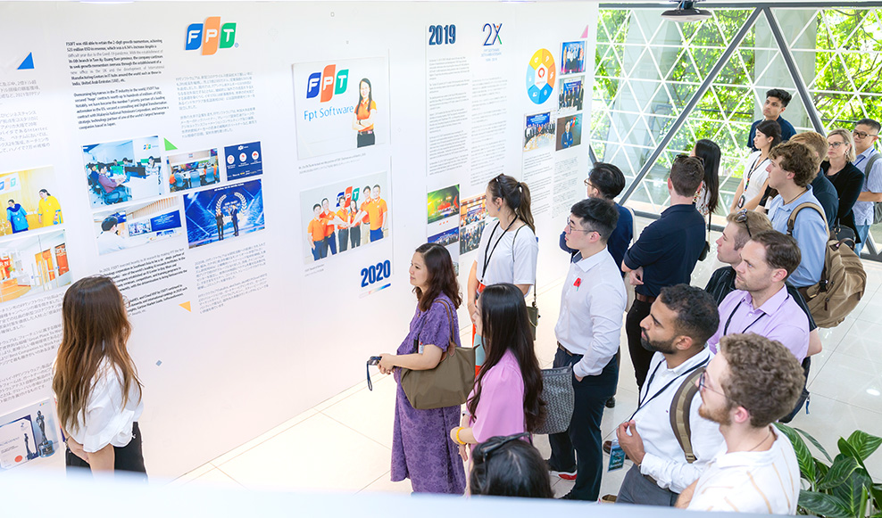 A group of about 15 Leadership Network members looking at a wall of text, photos and graphics information