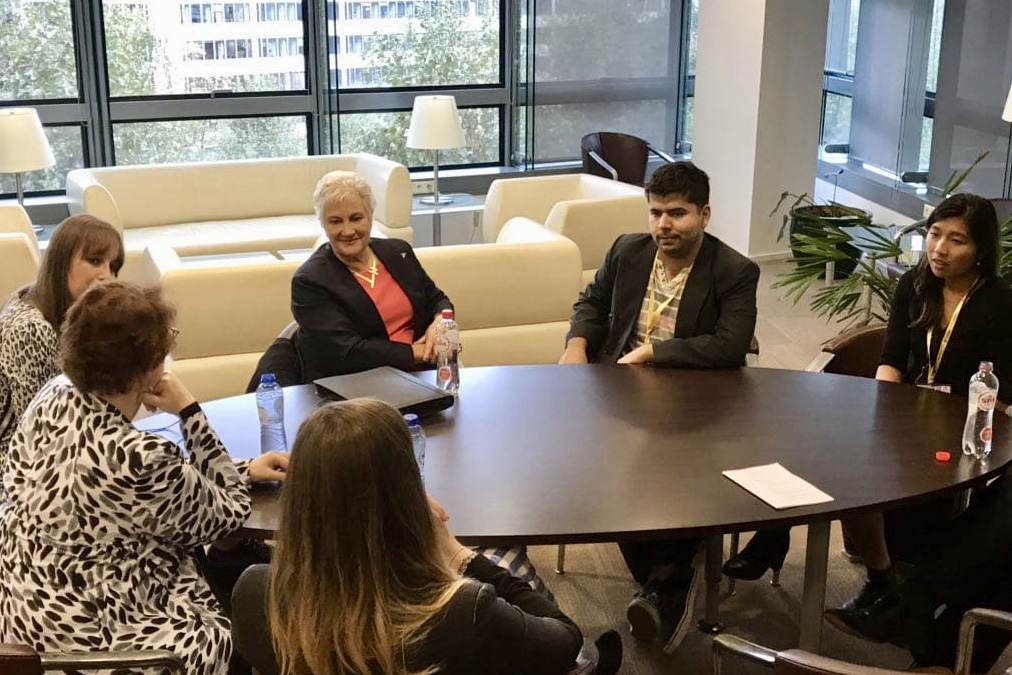 Anna Zam sitting at a table with members of New Zealand's Special Envoy