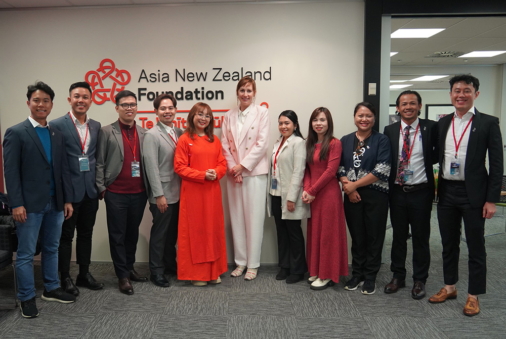 Suz standing with a group of visiting tourism entrepreneurs in front of the Foundation's sign in the Wellington office