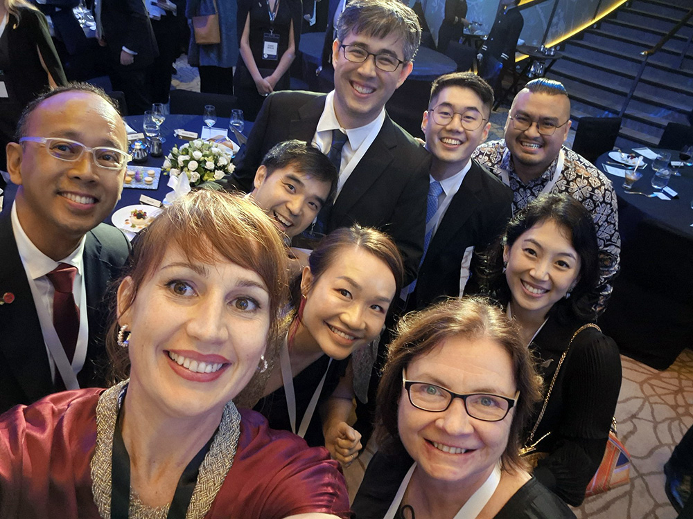 Suz taking a selfie with a group of eight people