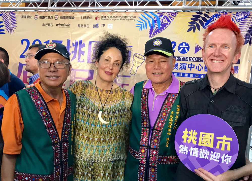 Four people standing with each other in colourful clothes taking picture