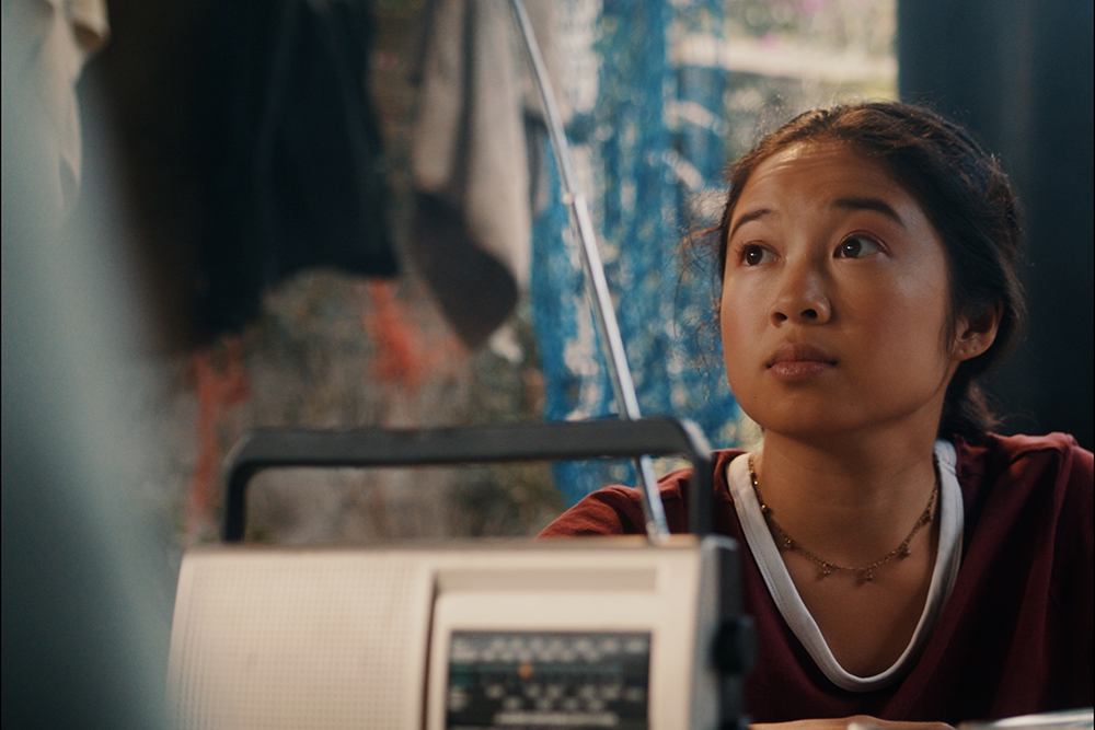 A scene from the film of a girl sitting at a table