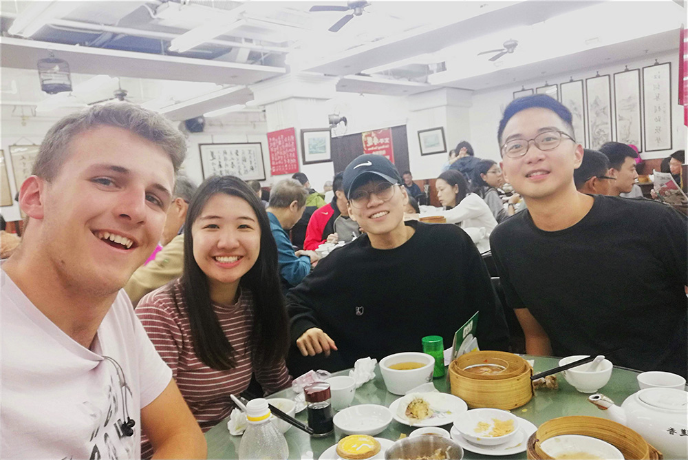 Tim taking a selfie at a restaurant with three friends