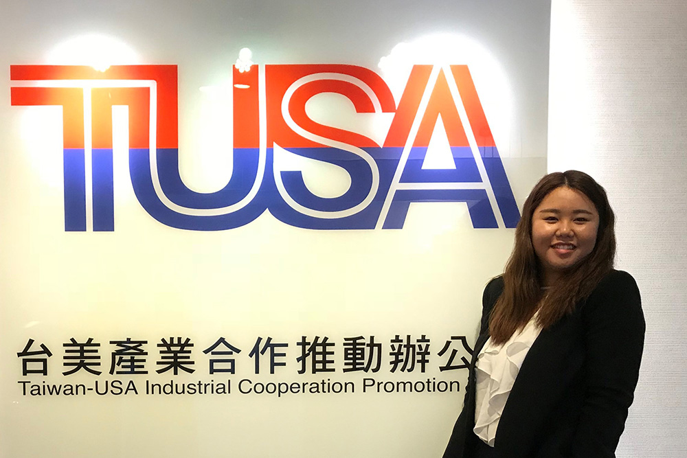 Tina standing in front of a TUSA sign