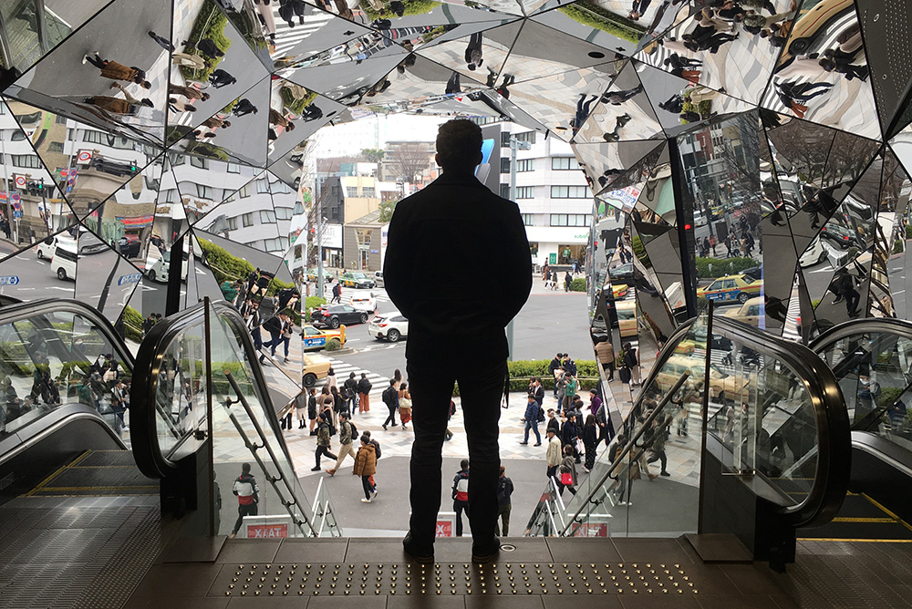 James standing in silhouette at the top of an esculator