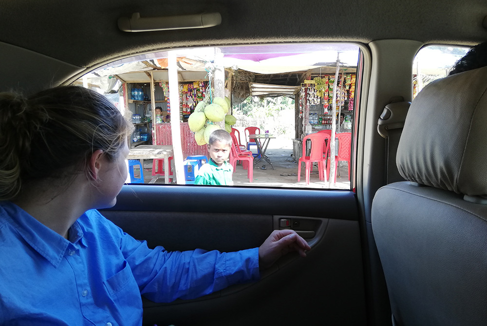 Jo looking out the window of a cab at a boy on the street