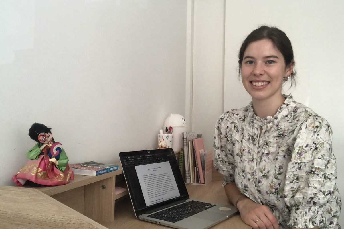 Holly sitting at a desk with a laptop on it