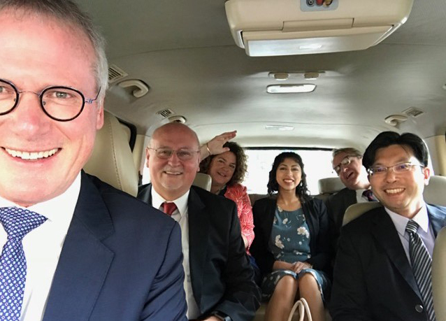group of adults sitting in the car looking at the camera
