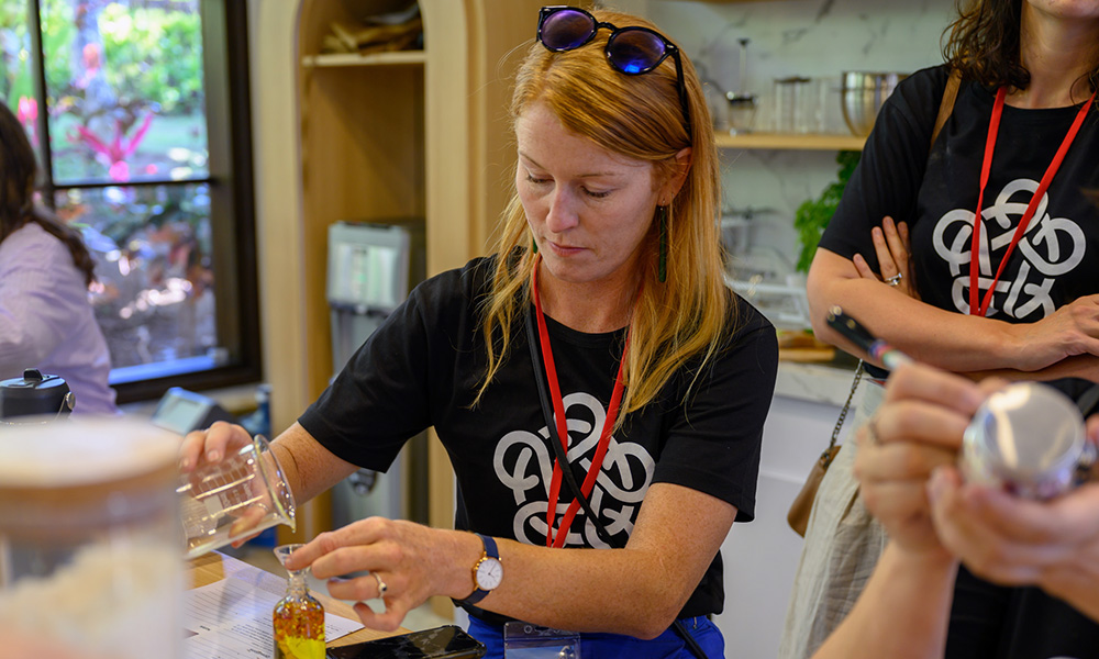 One of the entrepreneurs pouring a liquid from a beaker to a jar