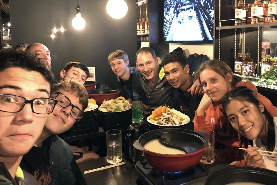 The team taking a group selfie around the dinner table