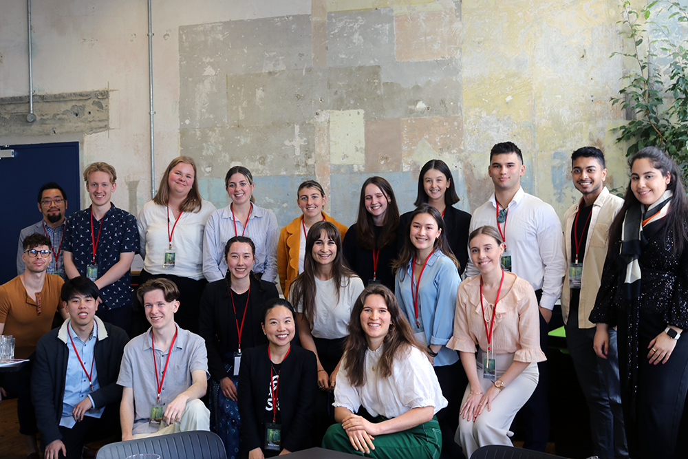 A group of about 20 young business interns posing