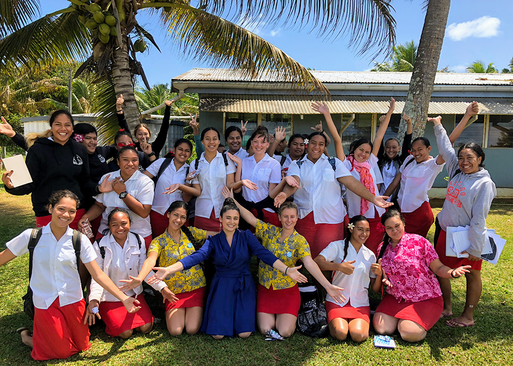 Alexia with a large group of high school girls in front of palm trees