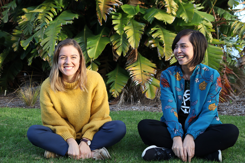 Crystal and fellow Leadership Network member Chloe Thompson sitting on the grass at Waitangi in 2019