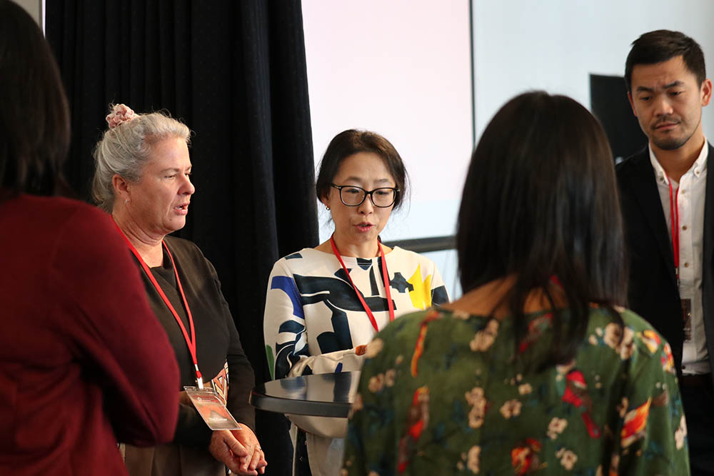 Five teachers standing in a circle chatting
