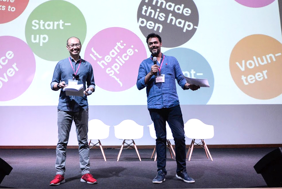 Two men on stage addressing an audience