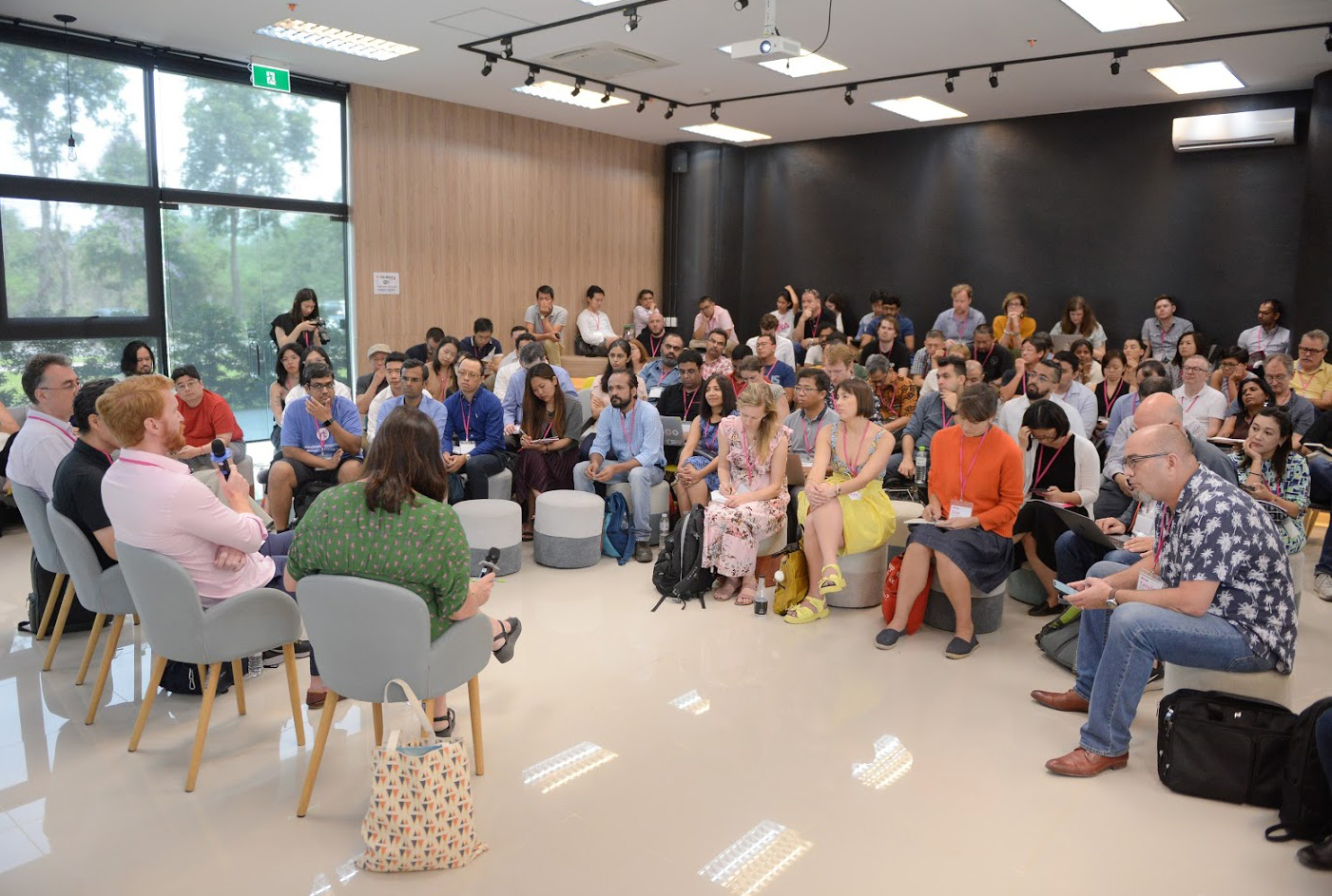 Four people sitting on chairs addressing an audience