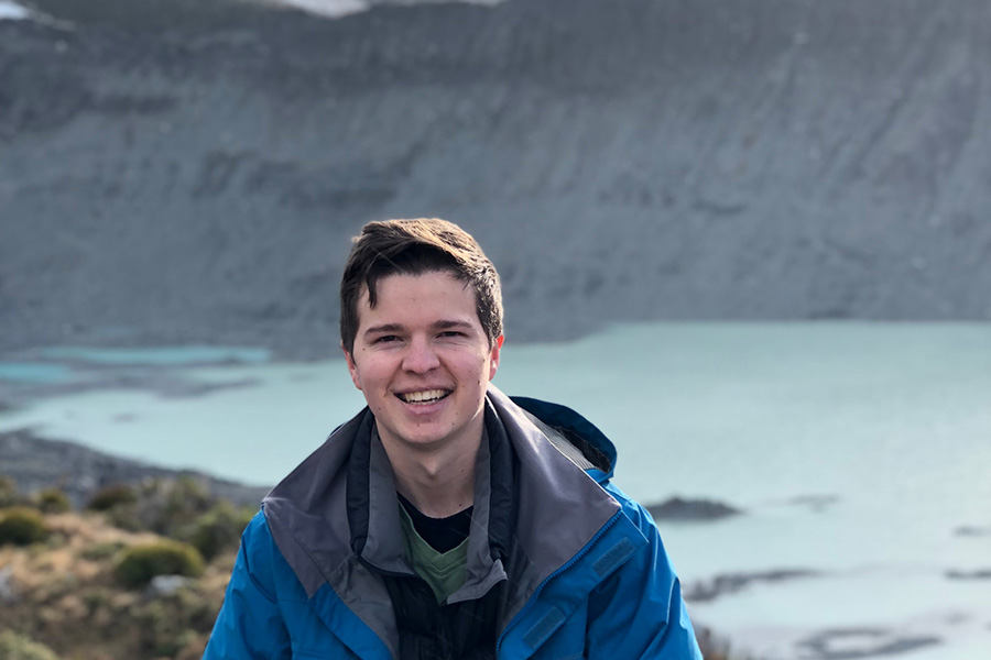 Jack Petterson standing in front of an alpine lake