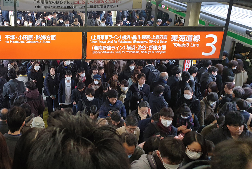People wearing face masks in a busy train stattion