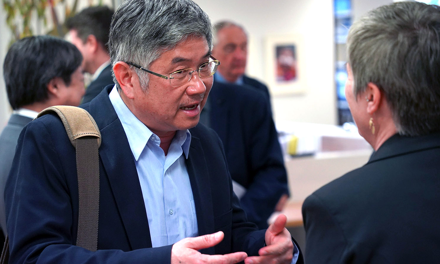 A man gesticulating as he speaks to a woman