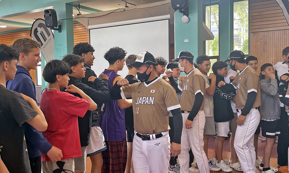 Students and Japanese players line up to bump elbows