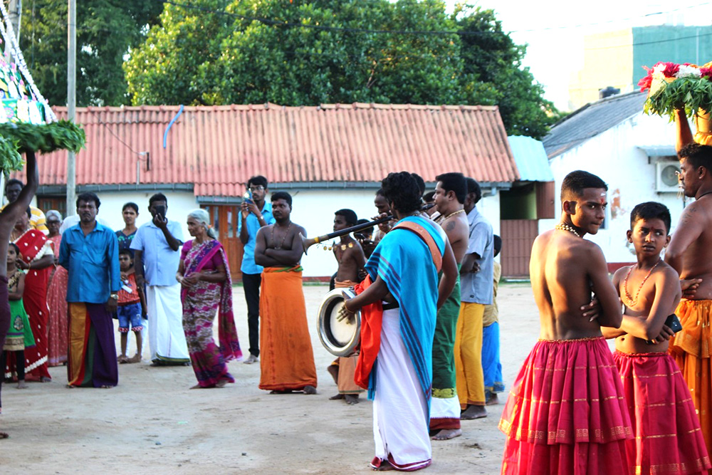 A group of people standing outside, some of them playing instruments