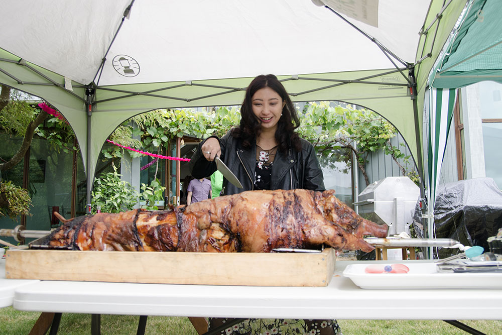 Jess cutting a pig on a spit