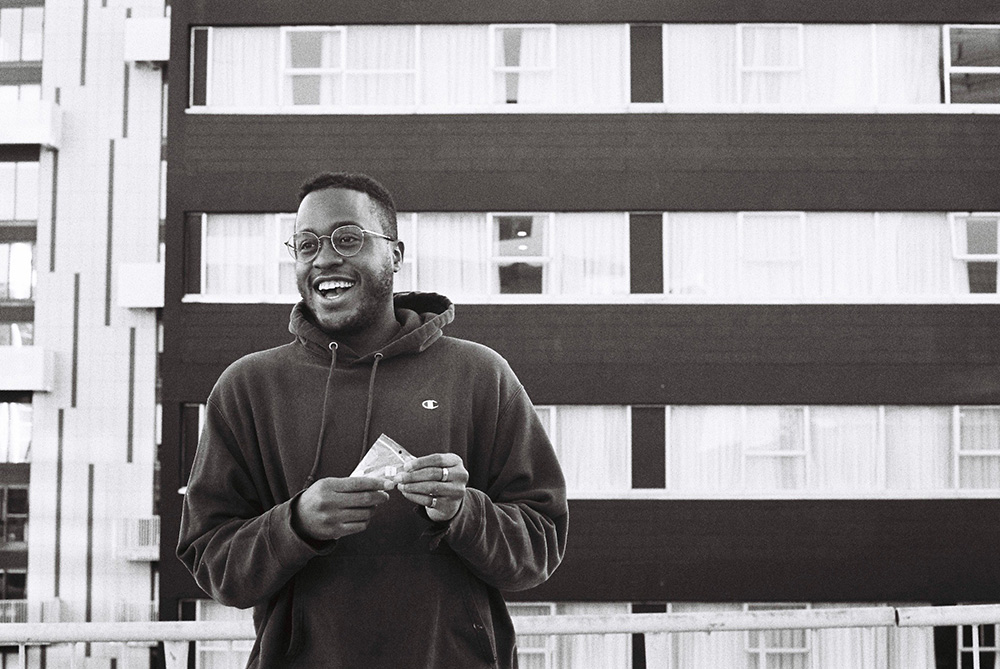 Kii standing in front of a block of flats