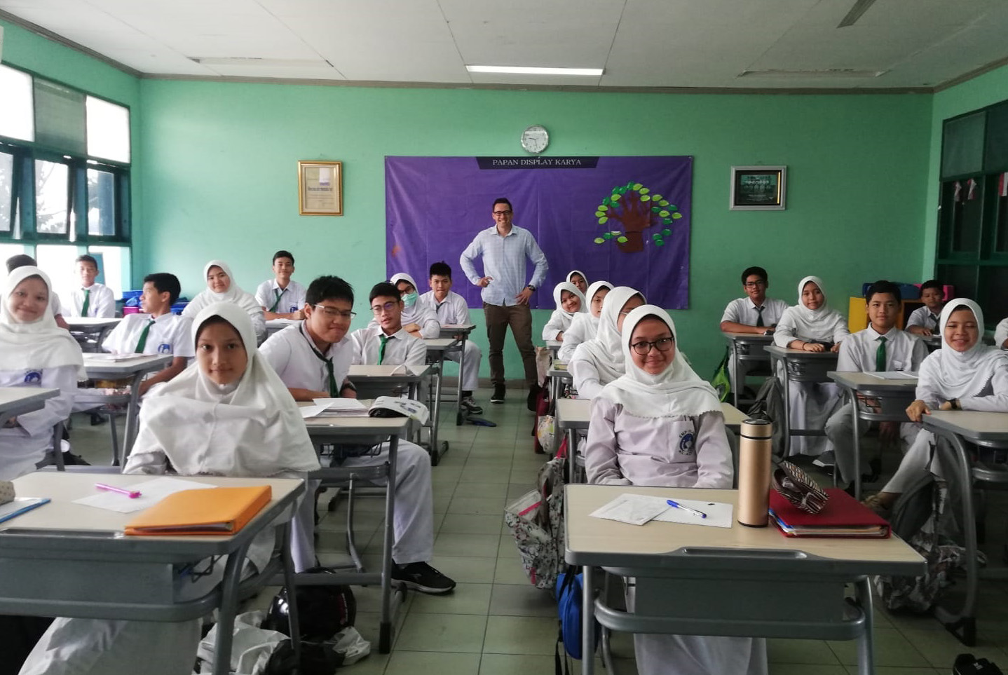 Kim Teo standing at the back of a classroom of students