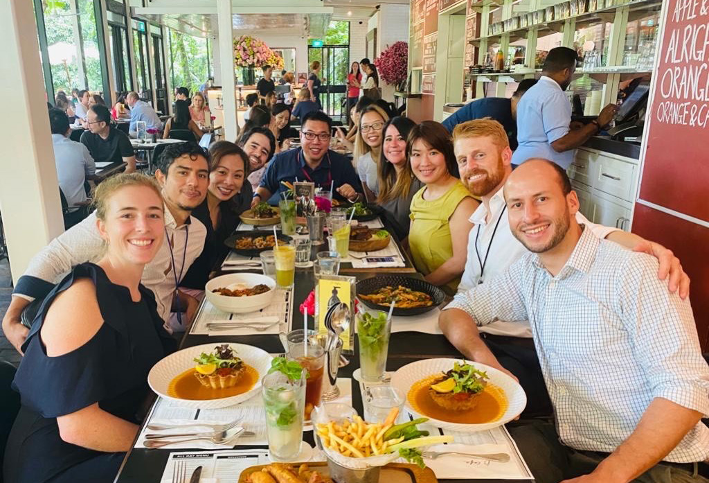 Klara having a meal in a restaurant with a large group of colleagues