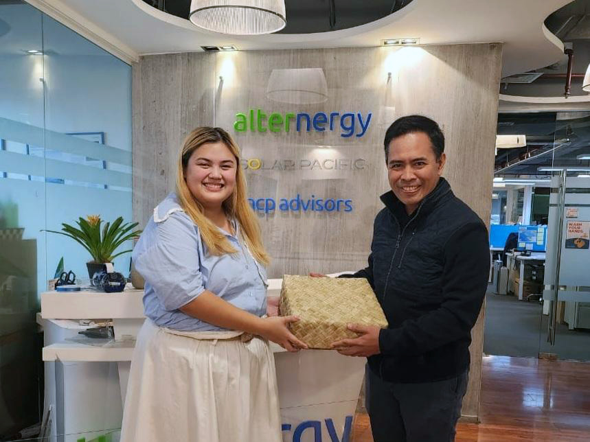Krychelle recieving a gift from a man in the Alternergy office