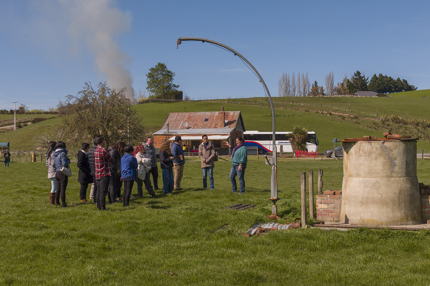 Rachell Gremmell talking to group of Leadership Network members in a paddock at Lawrence Chinese Camp with an old cottage in the background