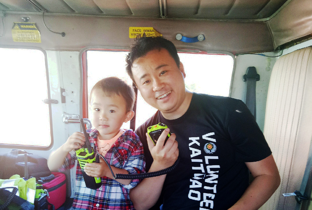 Luke with his son Jayden in the cab of a firetruck