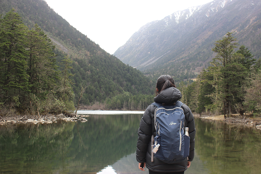 Mabel Ye looking out across a mountain lake