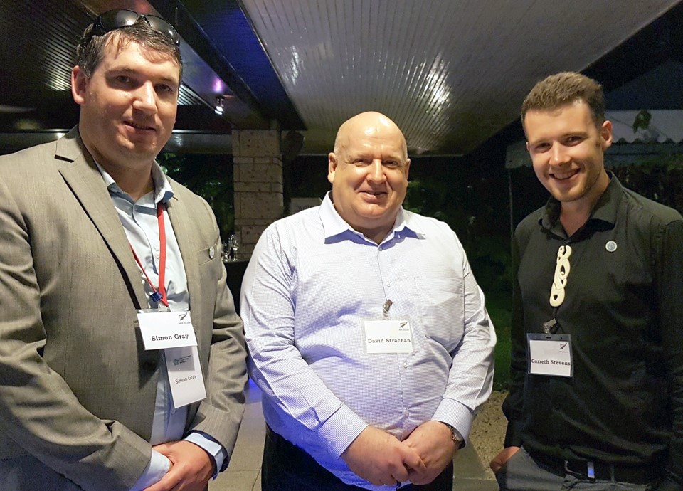 three men stand together