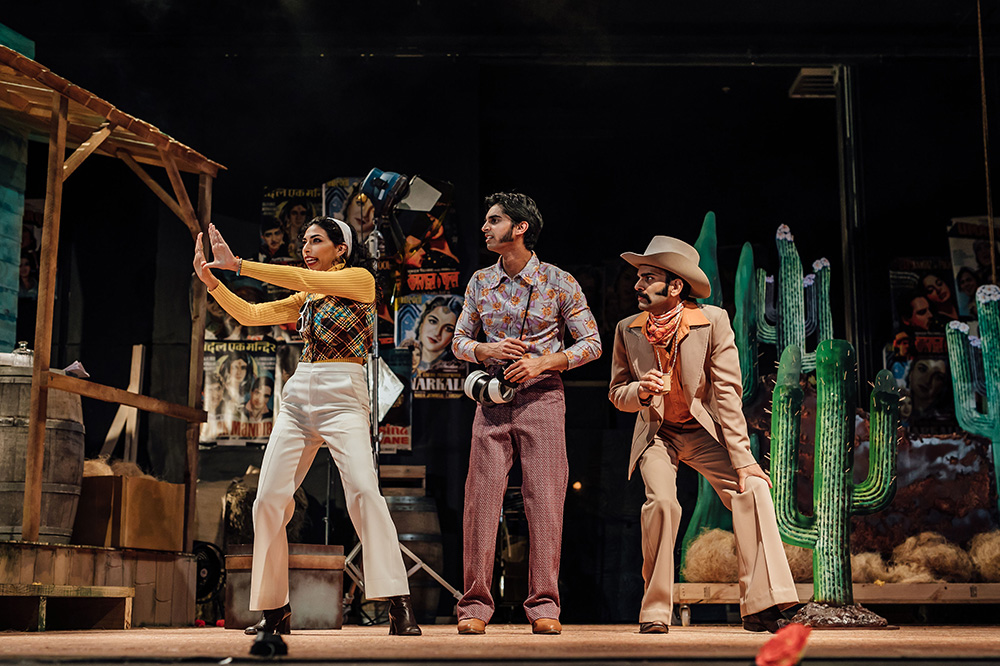 Actors dressed in 70s outfits on stage