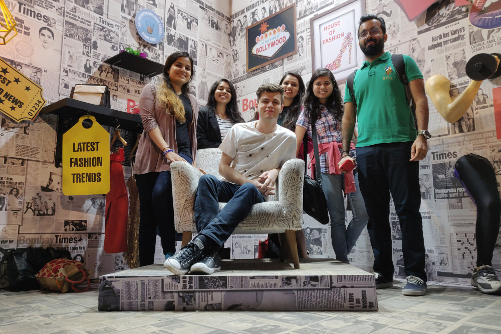 Nick sitting on a chair surrounded by his colleagues
