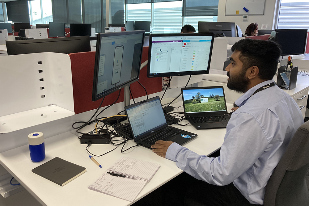 Nikhil looking at a computer in an office