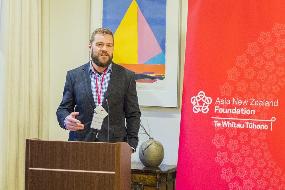 Shannon Goldsmith standing at a dias addressing a room