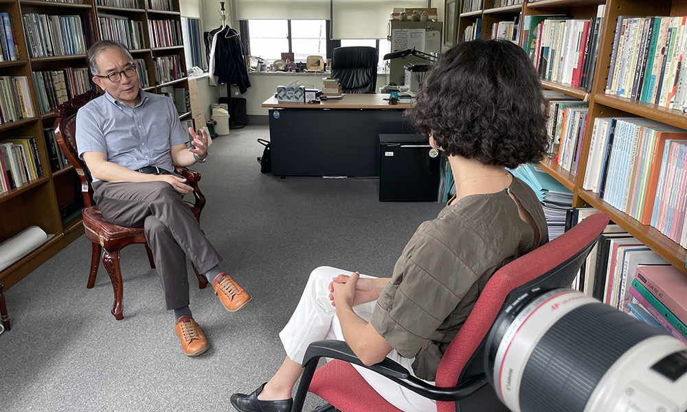 Shannon sitting across from international relations professor Lee Geun in an office full of books