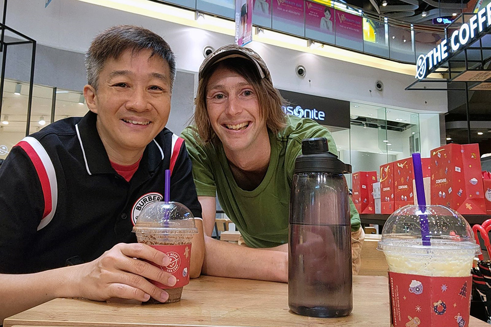 Oli and Transport consultant Terence Ng posing for a photo in a mall with ice drinks