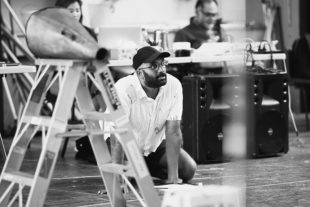 Ahi kneeling on stage watching a performance