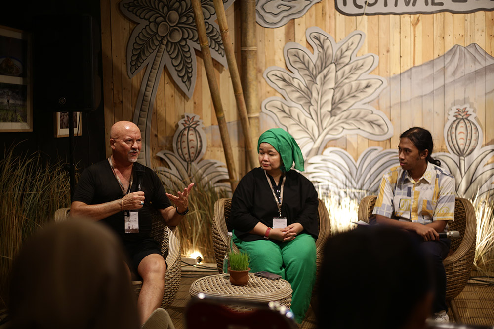 Robert Oliver speaking to an audience as part of a panel of three speakers